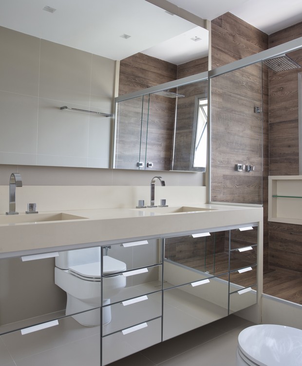 BANHEIRO | O banheiro ganhou bancada espelhada e revestimentos que imitam madeira (Foto: Denilson Machado/ Divulgação)