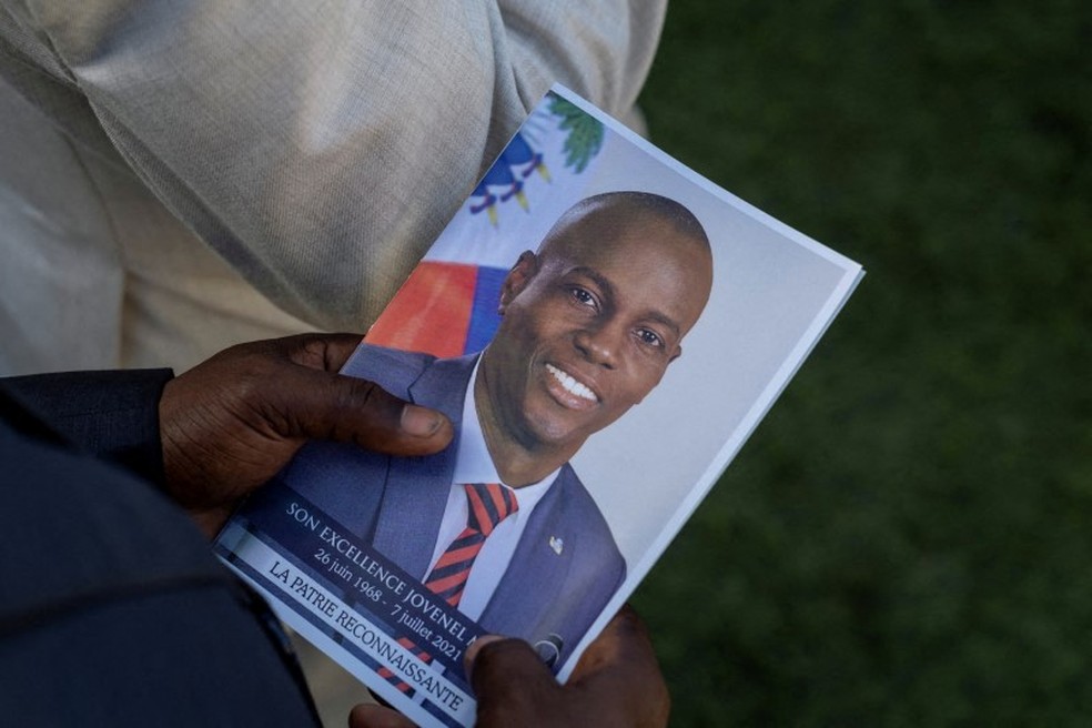 Uma pessoa segura foto do presidente assassinado do Haiti Jovenel Moise durante seu funeral em Cap-Haitien em 23 de julho — Foto: REUTERS/Ricardo Arduengo