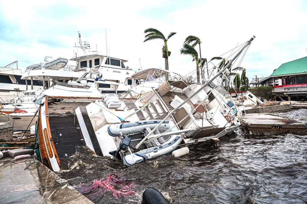 Barco é visto parcialmente submerso após passagem do furacão Ian em Fort Myers, na Flórida, nesta quinta-feira — Foto: Giorgio Viera/AFP