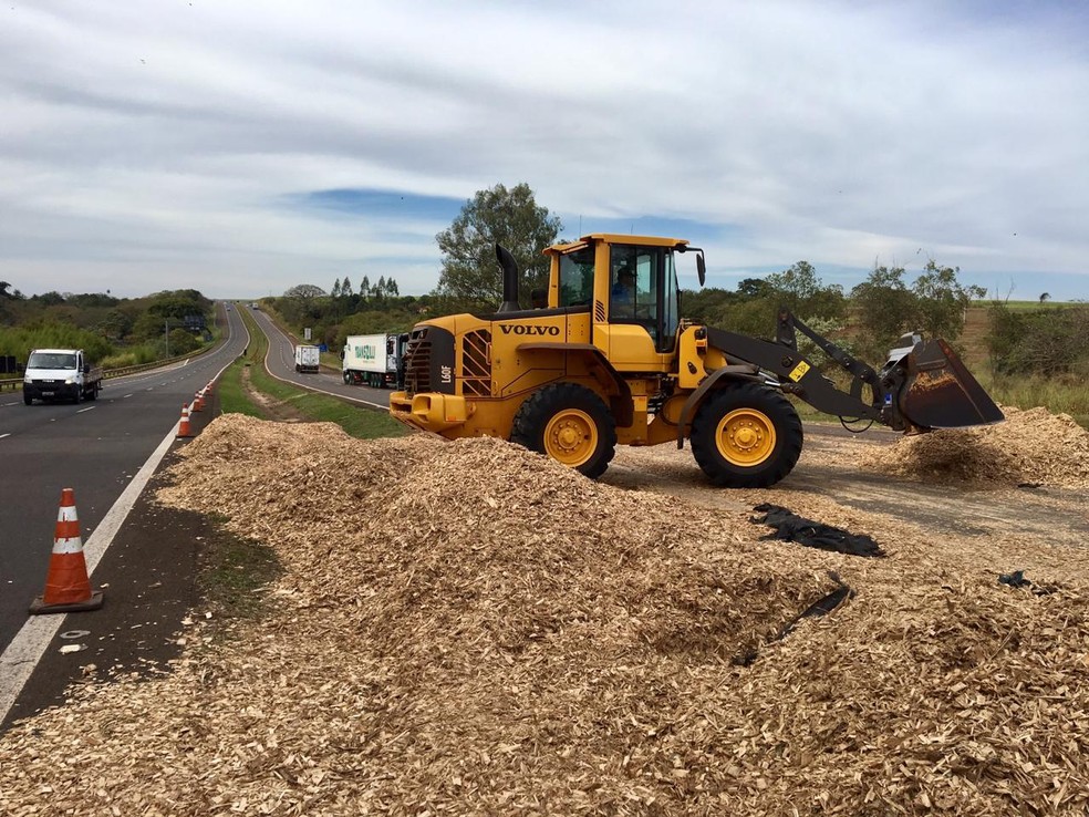 Pá-carregadeira foi utilizada para a retirada da carga de serragem que ficou espalhada: pista liberada no início da tarde — Foto: William Silva/TVTEM