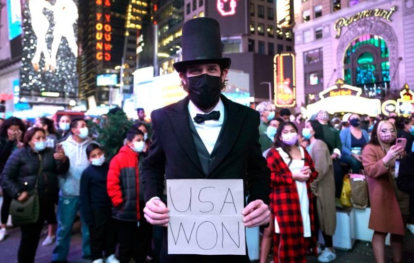 TOPSHOT - A man dressed as Abraham Lincoln holds a sign as people celebrate in the streets before US president-elect Joe Biden delivers remarks from Delaware, in Times Square, New York on November 7, 2020. - Democrat Joe Biden has won the White House, US  (Foto: AFP)
