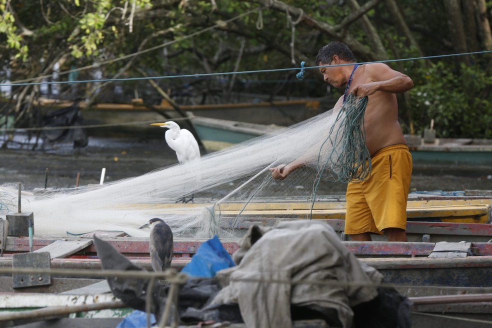 Pescador artesanal. Em tempos de lua cheia e nova, as embarcações ficam encalhadas a espera da maré — Foto: Custódio Coimbra
