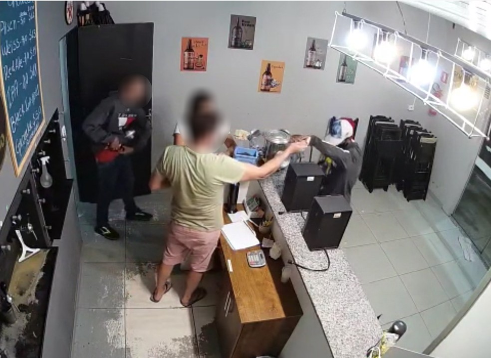 Vítima entrega parte do dinheiro que estava no caixa da choperia — Foto: Reprodução
