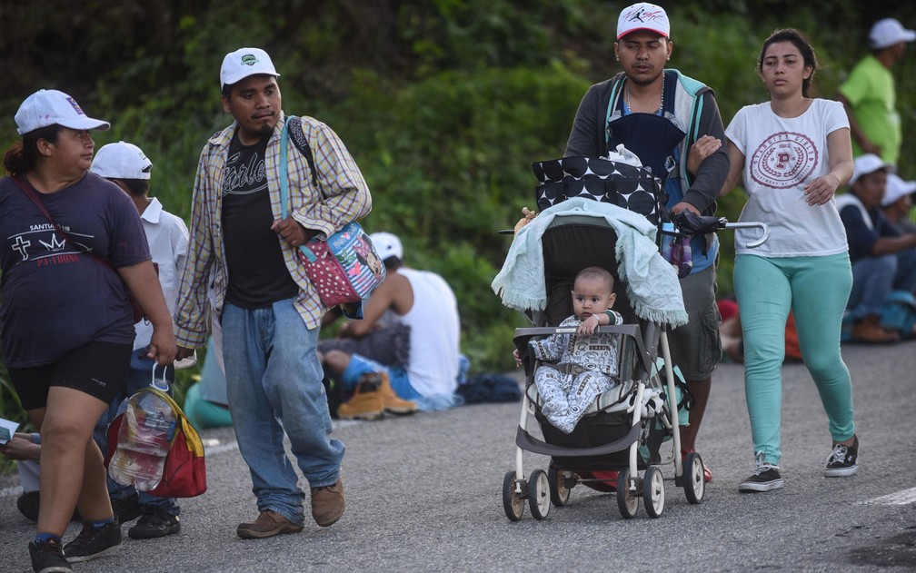 Família de migrantes hondurenhos caminha em estrada que liga Mapastepec a Pijijiapan, no estado de Chiapas, no México, na quinta-feira (25) — Foto: Johan Ordonez/AFP