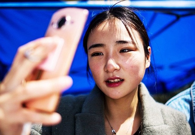 Jovem chinesa faz selfie durante curso de digital influencer na Yiwu Industrial and Commercial College (YWICC) (Foto: Johanes Eiselle/Getty Images)