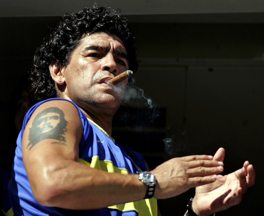 Foto de 19 de fevereiro de 2006 – Diego Maradona fuma um charuto enquanto aguarda o início de uma partida de futebol no estádio do Boca Juniors, em Buenos Aires — Foto: Marcos Brindicci/Reuters/Arquivo