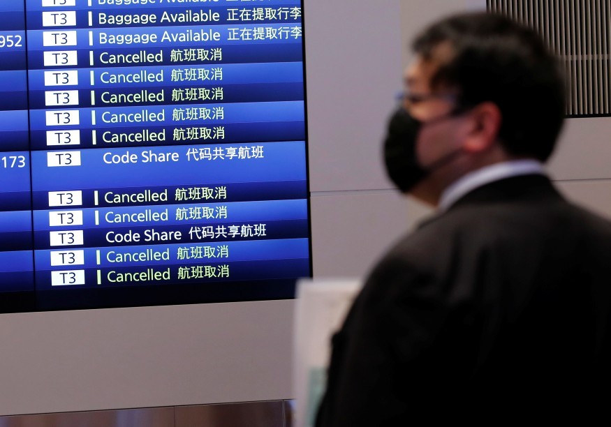 Monitor mostra pousos e decolagens no terminal internacional do aeroporto de Haneda, no Japão