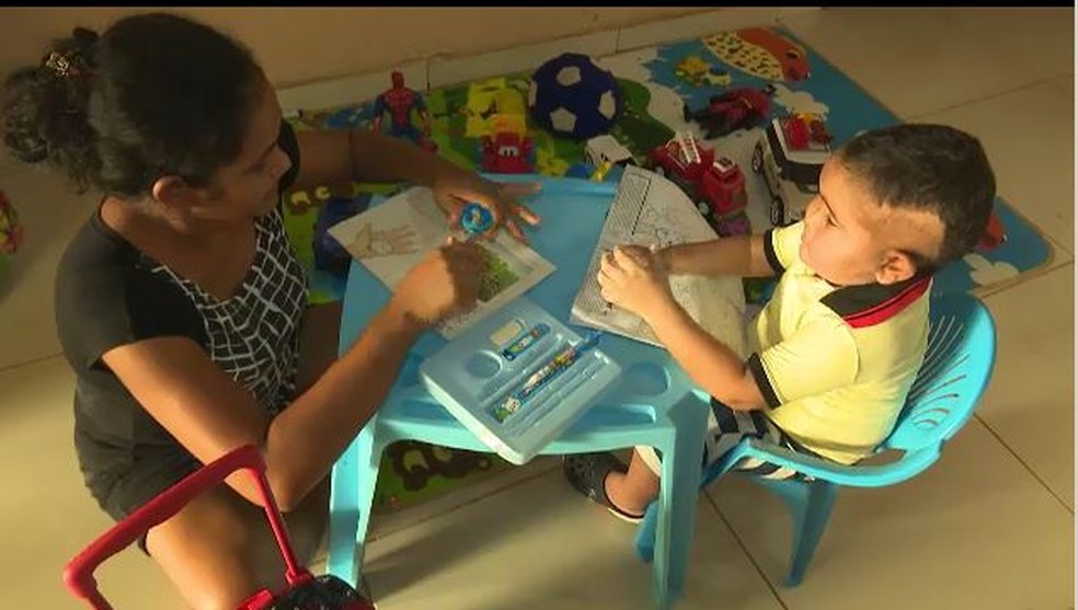Criança recebe lições e aprende a colorir  (Foto: Reprodução Rede Amazônica/Acre)