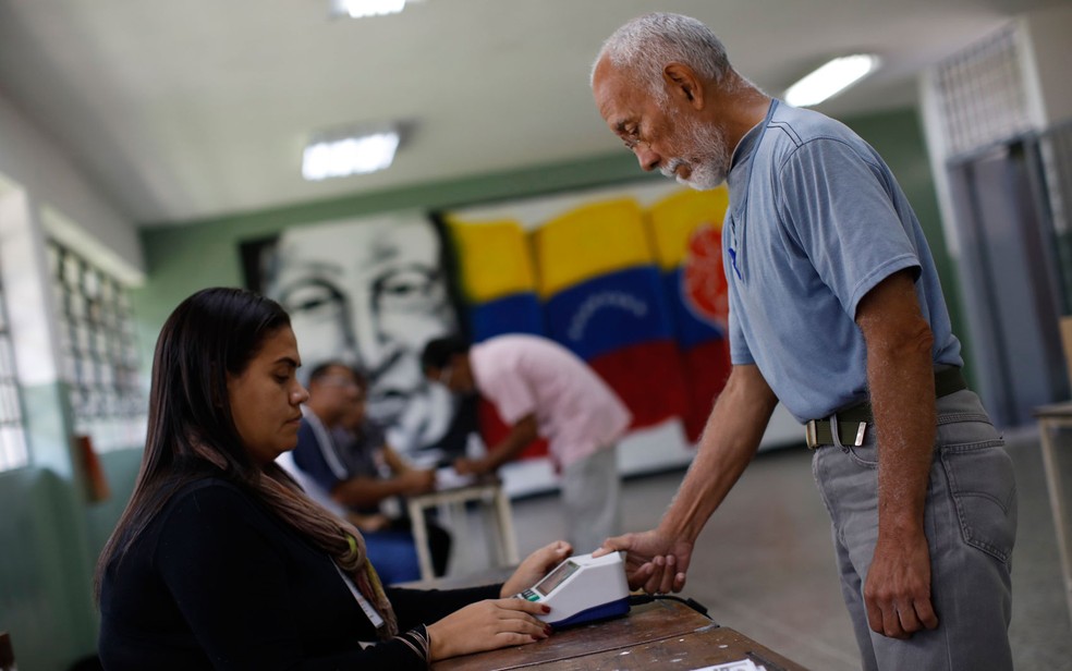 Eleitor se identifica antes de votar para a Assembleia Constituinte em Caracas, na Venezuela, no domingo (30) (Foto: Reuters/Carlos Garcia Rawlins)