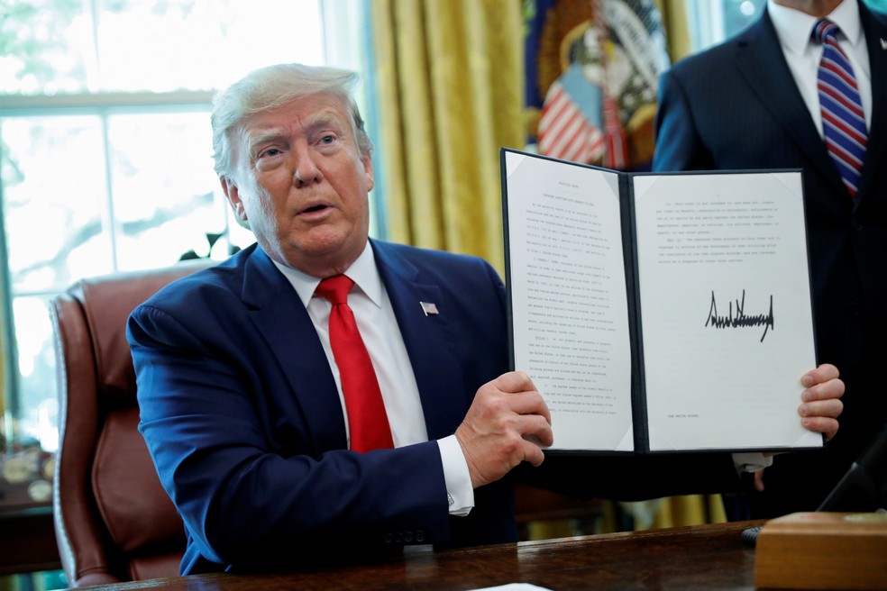 Donald Trump exibe assinatura em ordem executiva que impõe novas sanções ao Irã — Foto: Carlos Barria/Reuters