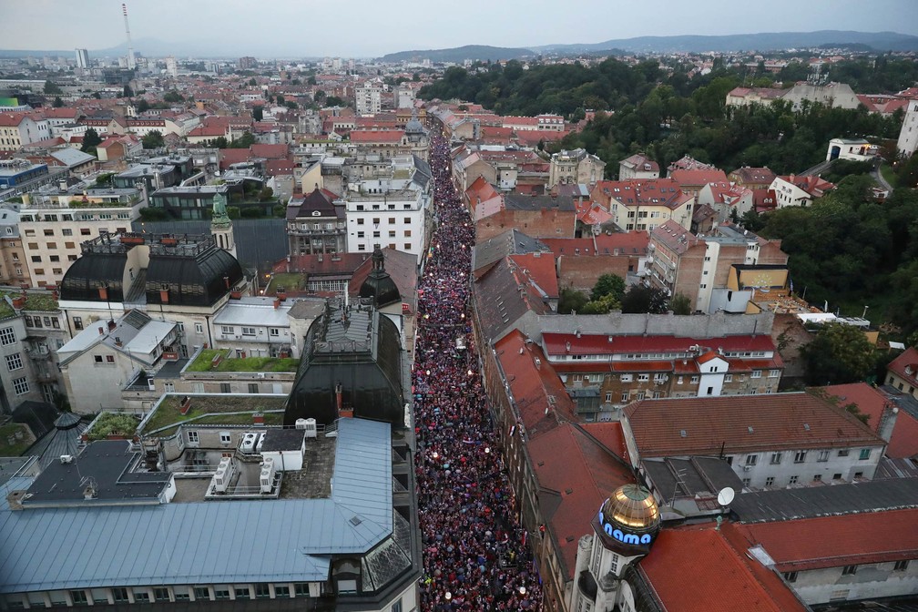 MultidÃ£o lota rua de Zagreb vestida com as cores da bandeira da CroÃ¡cia, Ã  espera da passagem da seleÃ§Ã£o em carro aberto no retorno apÃ³s a Copa do Mundo (Foto: Marko Djurica/Reuters)
