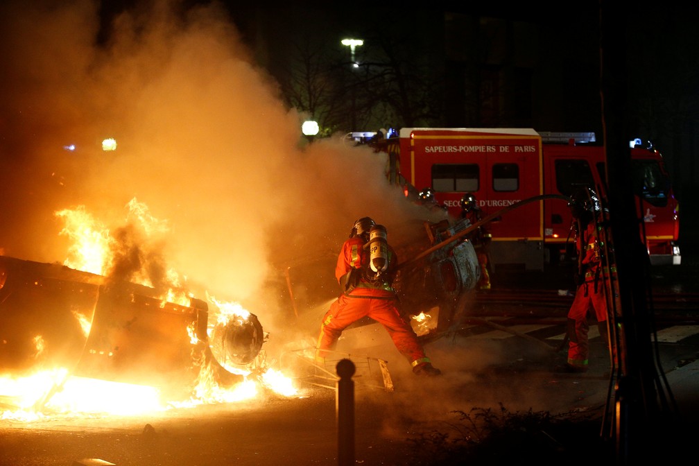 Bombeiros tentam apagar chamas de carro após protesto em Paris — Foto: REUTERS/Stephane Mahe