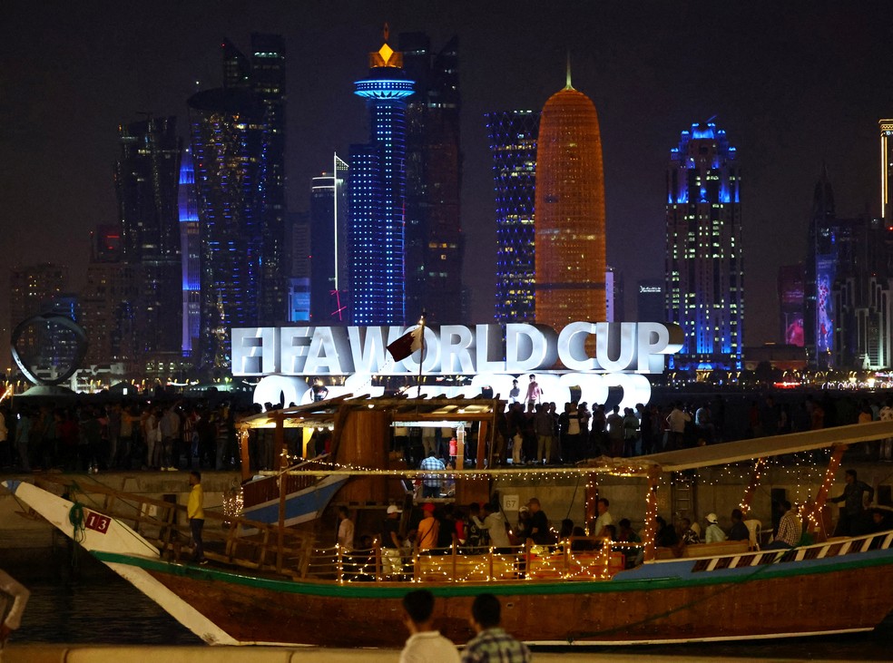Imagem de pessoas na frente de letreiro da Fifa em Doha, em 18 de novembro de 2022 — Foto: Fabrizio Bensch/Reuters