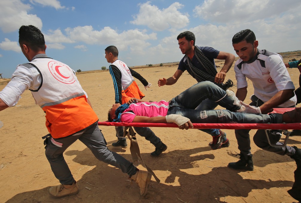 Palestino ferido em confronto na fronteira da Faixa de Gaza com Israel nesta segunda-feira (14) Ã© transportado (Foto: Said Khatib/AFP)