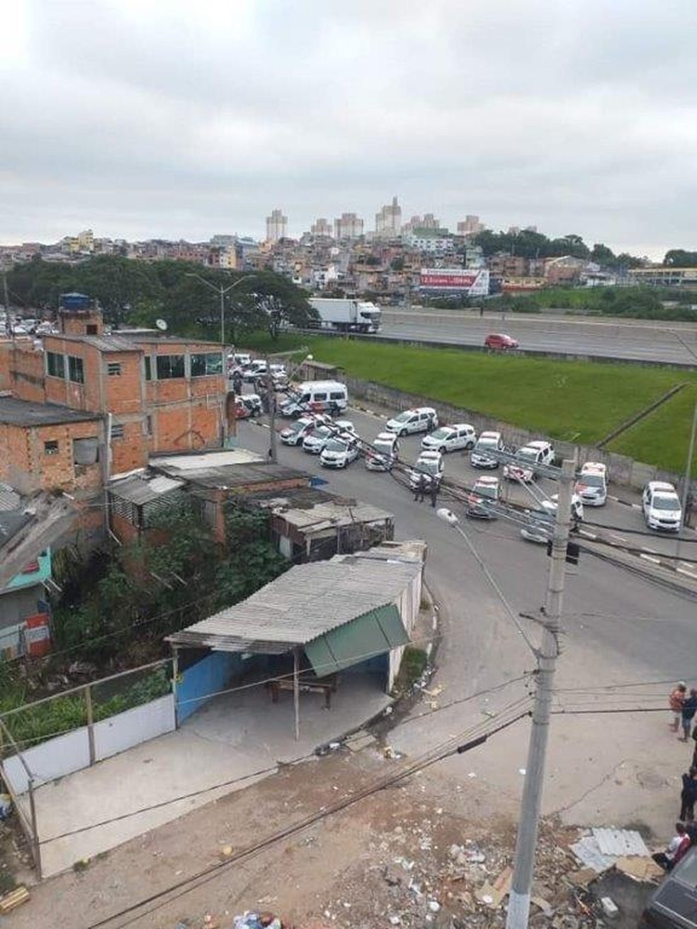 Foto que circula nas redes sociais mostra viaturas da PM ao fundo e comunidade próxima ao local onde dois suspeitos foram mortos por policial à paisana em Osasco — Foto: Reprodução/Redes sociais