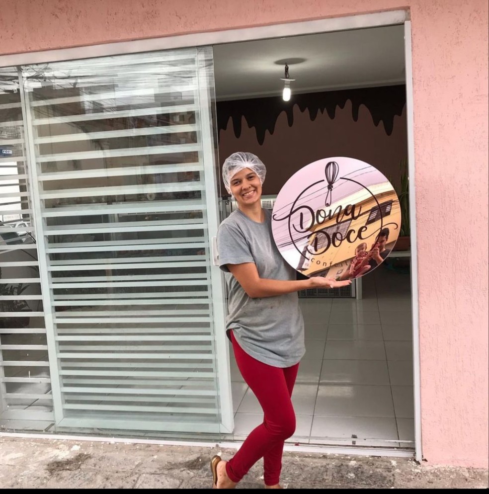 Yasmin Gouveia ao lado da placa do negócio que montou em Caruaru e cresceu durante a pandemia — Foto: Arquivo pessoal