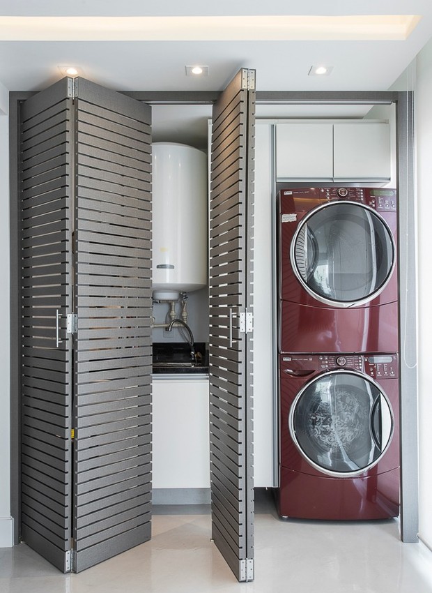 Uma opção para pequenos espaços é "camuflar" a lavanderia e a máquina de lavar em um armário com portas.O projeto do escritório Spazio Arquitetura tem portas ventiladas, para não superaquecer o motor (Foto: Divulgação)