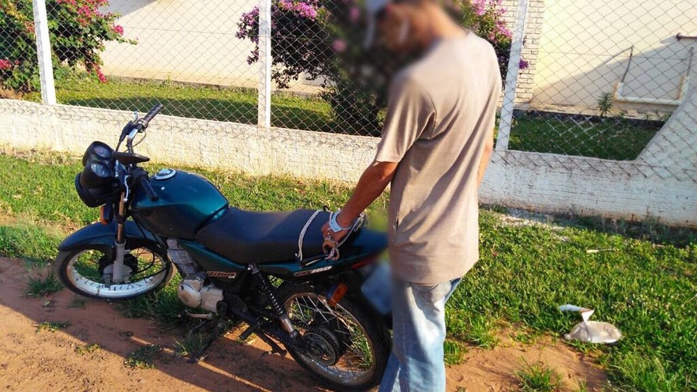 Um dos suspeitos de cometer o crime foi algemado à moto da vítima até ser lavado para a delegacia (Foto: Osvaldo Nóbrega/TV Morena)
