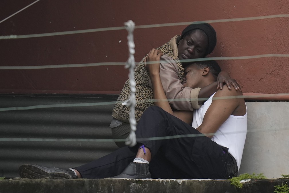Moradores se abraçam após deslizamento no Morro da Oficina, em Petrópolis (RJ) — Foto: Silvia Izquierdo/AP