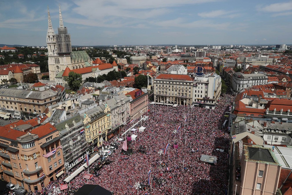 MultidÃ£o lota praÃ§a de Zagreb vestida com as cores da bandeira da CroÃ¡cia, Ã  espera da passagem da seleÃ§Ã£o em carro aberto no retorno apÃ³s a Copa do Mundo (Foto: Marko Djurica/Reuters)