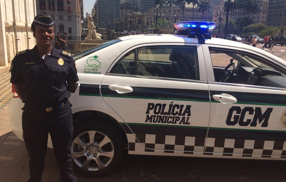 Guarda posa ao lado de novo carro da GCM já adesivado com as palavras Polícia Municipal (Foto: Will Soares/G1)