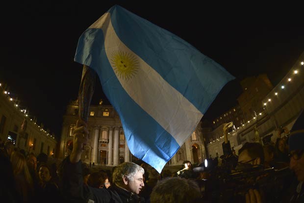 Fiel acena bandeira da Argentina nesta quarta-feira (13) na Praça de São Pedro, no Vaticano (Foto: AP)