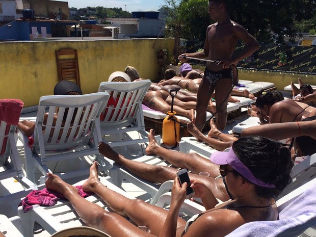 Para afastar o calor, mulheres chamam o &#39;bombeiro&#39;, que borriga água nelas (Foto: Lívia Torres/G1)