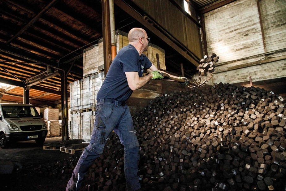 Trabalhador carrega briquetes de carvão no armazenamento do negócio de produtos de aquecimento 'Hans Engelke Energie' em Berlim.