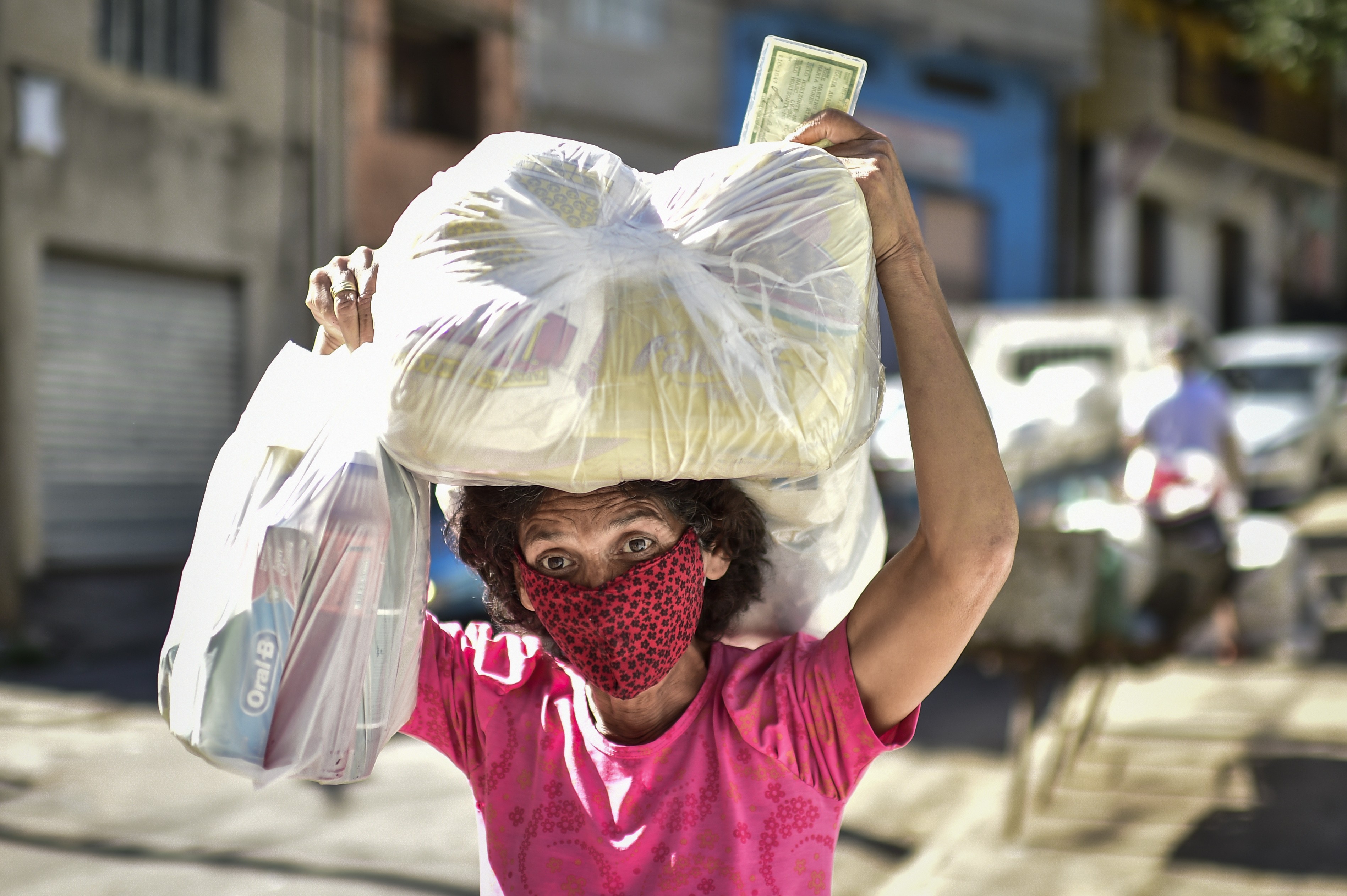 Mulher, moradora da Favela da Serra Aglomerado, recebe alimentos em Belo Horizonte (Foto: Pedro Vilela/Getty Images)