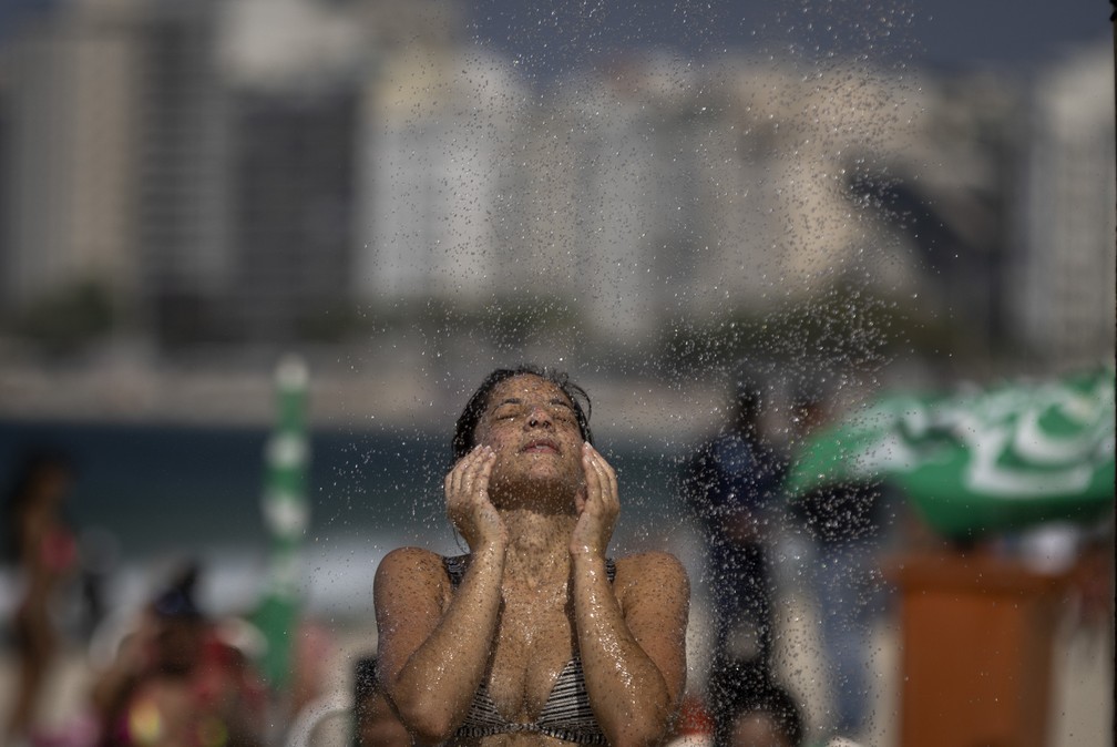 Banhista se refresca no chuveiro na Praia de Copacabana — Foto: Márcia Foletto