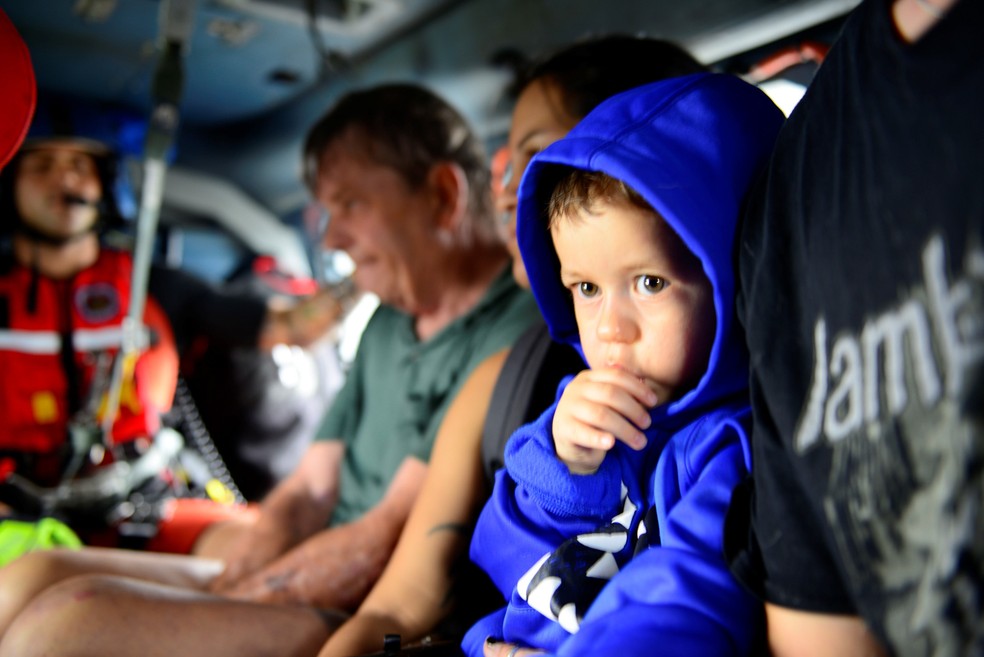 Uma criança é vista entre as pessoas evacuadas por um helicóptero da Guarda Costeira dos EUA após inundações em diversos bairros devido à passagem do furacão Harvey em Houston. Foto tirada no domingo (27) e divulgada nesta segunda (28) (Foto: Johanna Strickland/Guarda Costeira dos Estados Unidos/via Reuters)