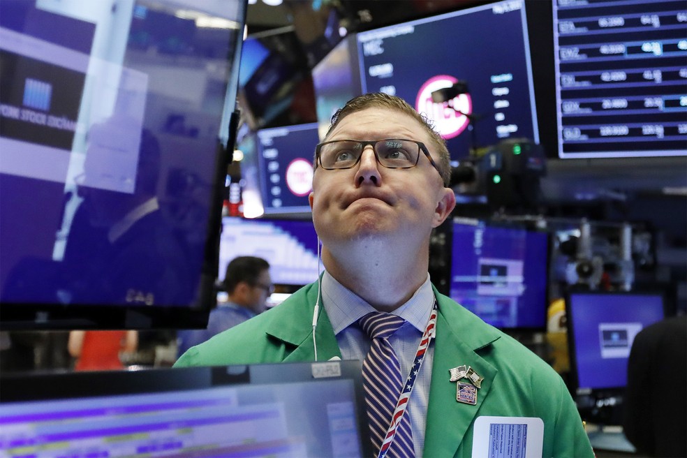 Operador observa telões durante dia de trabalho na Bolsa de Nova York, nos EUA — Foto: Richard Drew/AP