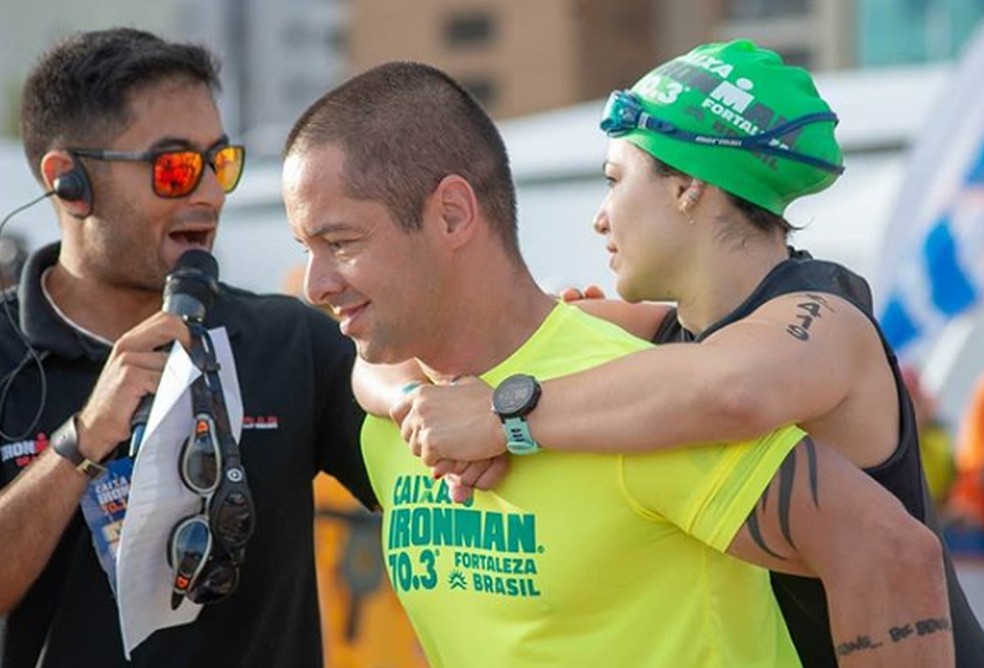 MÃ¡rcio carrega Dani nas costas minutos antes da largada do Meio Ironman â Foto: Elton Viana