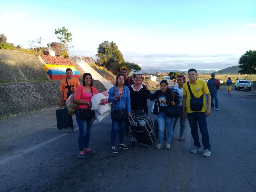 Diana Astudillo (de blusa azul claro), com grupo de venezuelanos que atravessou para o lado brasileiro por um caminho alternativo, as chamadas trincheiras â€” Foto: Alan Chaves/G1