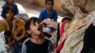 Agente de saúde administra a vacina contra a poliomielite em uma escola durante uma campanha de vacinação em Lahore, no Paquistão — Foto: Arif ALI / AFP