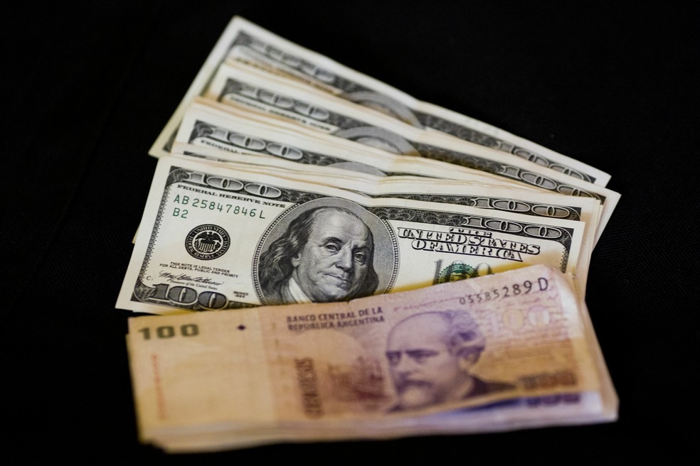 Foto mostra notas de dólares e pesos argentinos em casa de câmbio em Buenos Aires (Foto: Victor R. Caivano/Arquivo AP Photo)