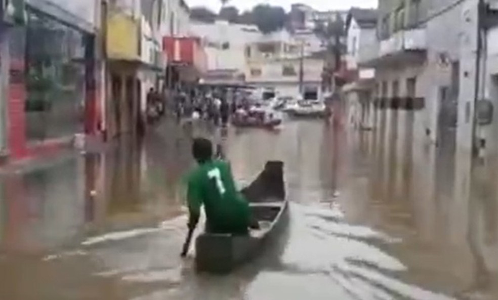 Moradores de Medeiros Neto usam canoas para poder se deslocar após nível de rio subir — Foto: Reprodução / TV Bahia
