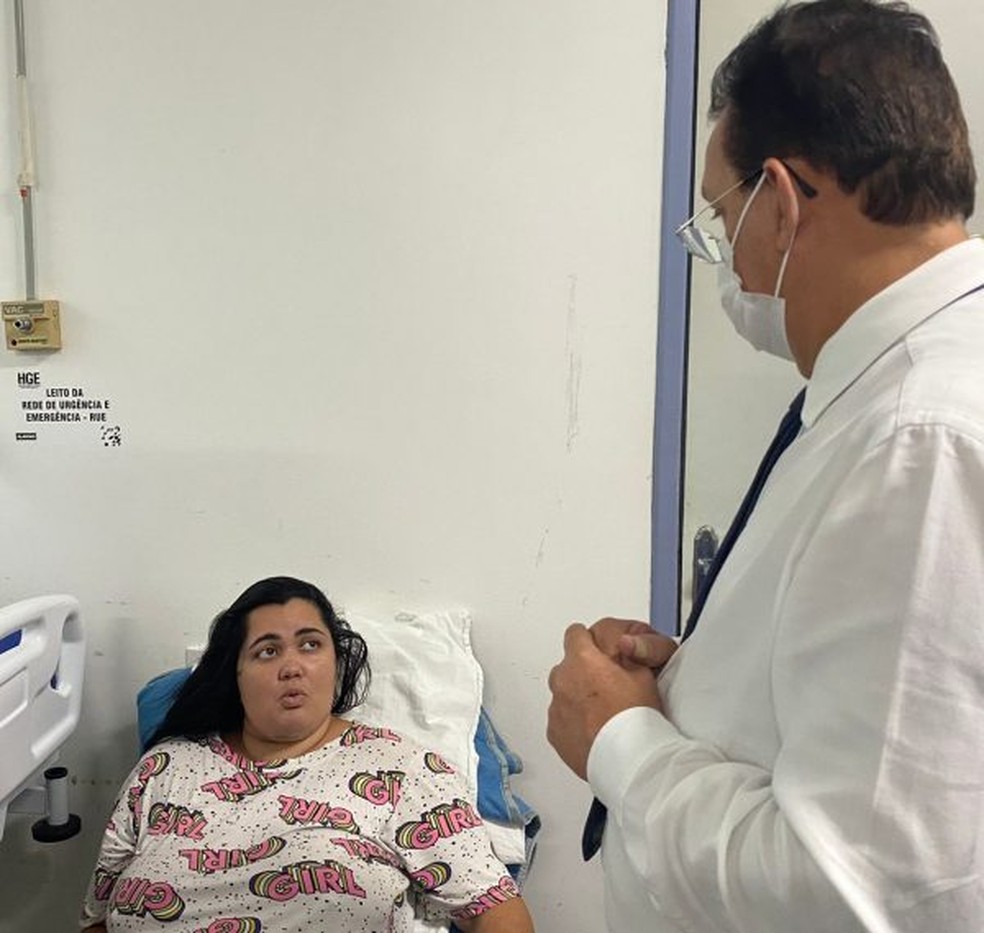 Motorista por aplicativo Alayne Oliveira, baleada na cabeça em tentativa de latrocínio em Maceió, e o gerente do HGE,  médico Paulo Teixeira. — Foto: Ascom HGE