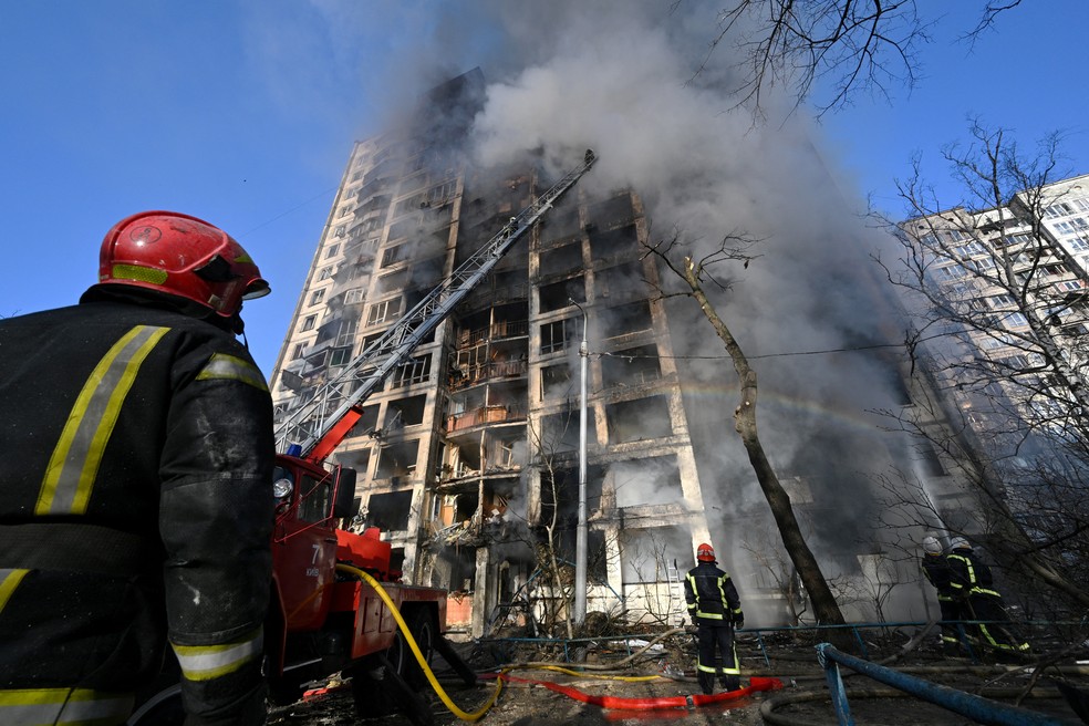 Bombeiros apagam incêndio em prédio residencial de 16 andares em Kiev, capital da Ucrânia, no dia 15 de março de 2022 — Foto: Sergei Supinsky/AFP