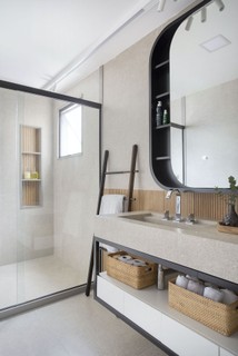 Base cinza, com texturas de cimento e toques quentes de madeira é o conceito que rege este banheiro. A bancada e o revestimento cinza do piso e da parede são da Portinari Veneto e o porcelanato ripado, da Ceusa
