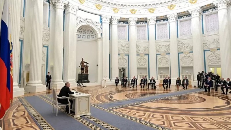Nos dias que antecederam a invasão, a TV russa transmitiu uma sessão do conselho de segurança de 30 membros do presidente Putin (Foto: RUSSIAN PRESIDENCY)