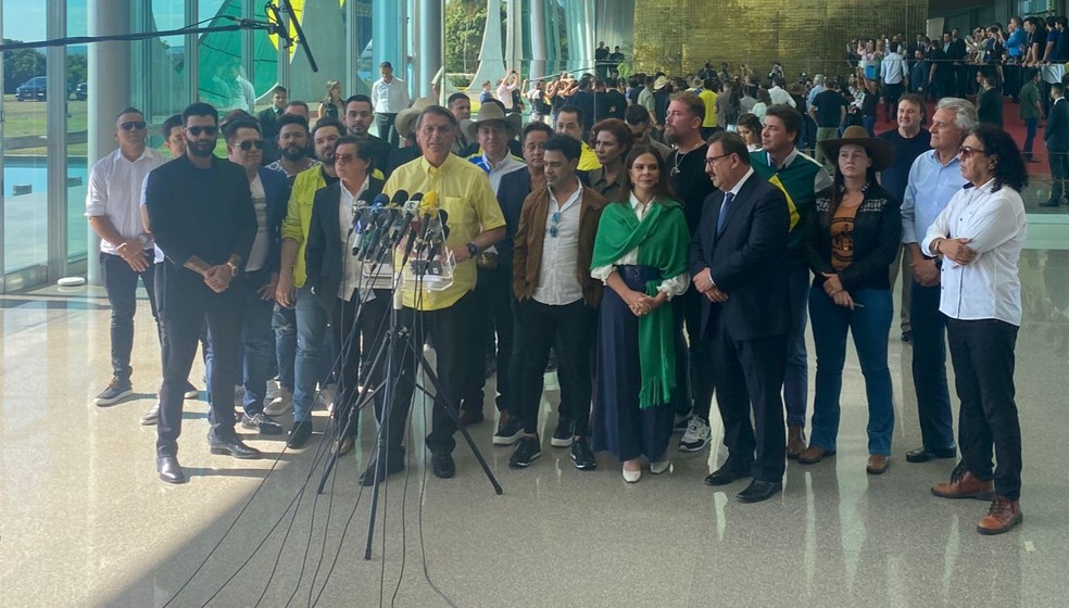 O presidente Jair Bolsonaro faz declaração à imprensa ao lado de artistas sertanejos — Foto: Guilherme Mazui/g1
