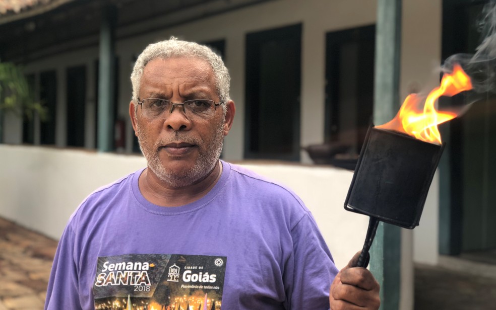 O jardineiro Valdivino Dias Carneiro, de 48 anos, que montou com a ajuda do filho e do sobrinho as 500 tochas que serão dadas aos visitantes durante a Procissão do Fogaréu, na cidade de Goiás  — Foto: Paula Resende/G1