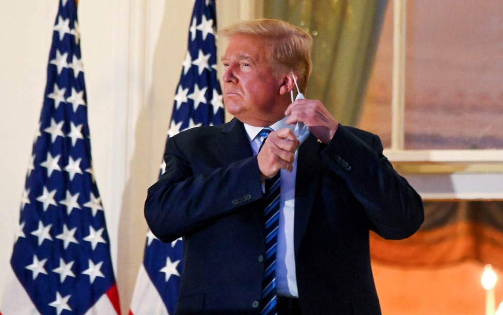 O então presidente dos EUA, Donald Trump, tira sua máscara enquanto posa na Casa Branca, em 5 de outubro de 2020, após receber alta do hospital em que ficou internado para tratar a Covid-19 — Foto: Erin Scott/Reuters