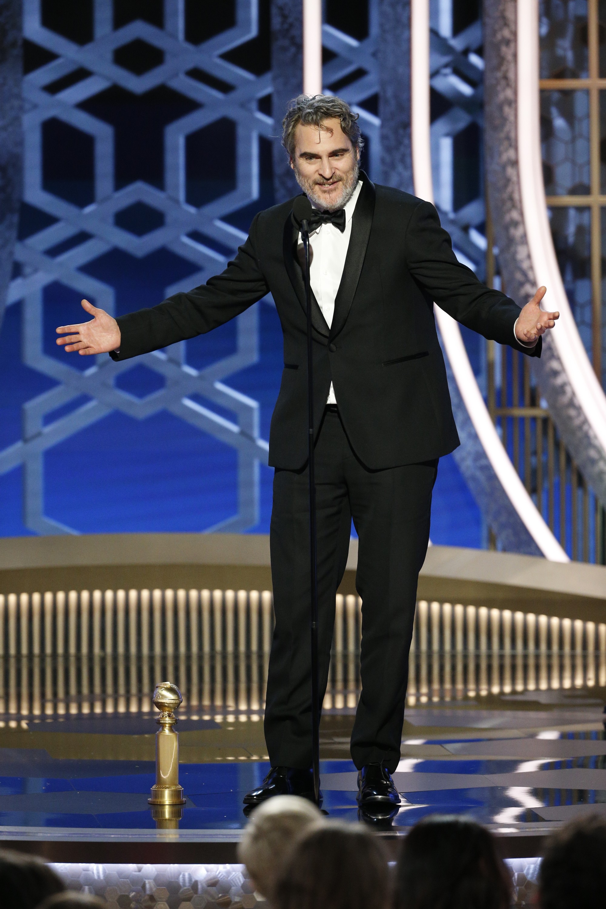 O ator Joaquin Phoenix em seu discurso de agradecimento no Globo de Ouro 2020 após vencer o prêmio na categoria de Melhor Ator em Drama por seu trabalho em Coringa. A troféu vencido pelo ator está no chão.  (Foto: Getty Images)