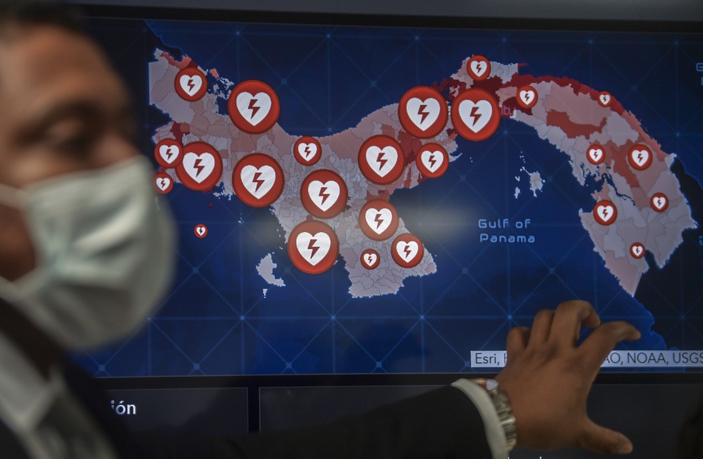 Um membro do Centro de Operações de Emergência em Saúde (CODES) mostra um mapa do Panamá com os locais dos centros de atendimento em todo o país para pacientes com o coronavírus Covid-19, na Cidade do Panamá em 30 de março — Foto: Luis Acosta/AFP