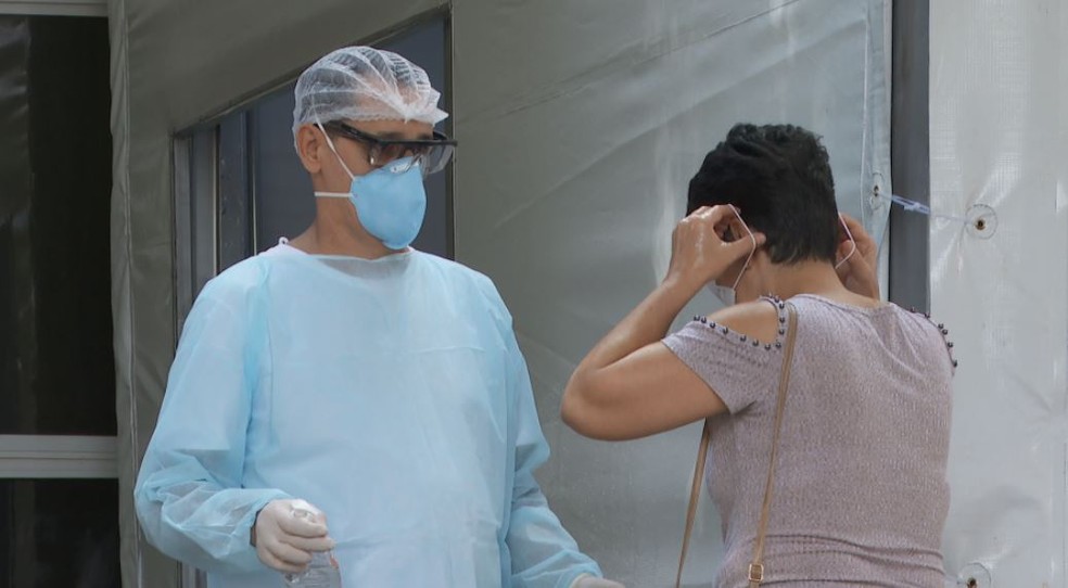 Profissional de sa&uacute;de recebe paciente no polo Covid-19 em Ribeir&atilde;o Preto (SP) &mdash; Foto: Reprodu&ccedil;&atilde;o/EPTV