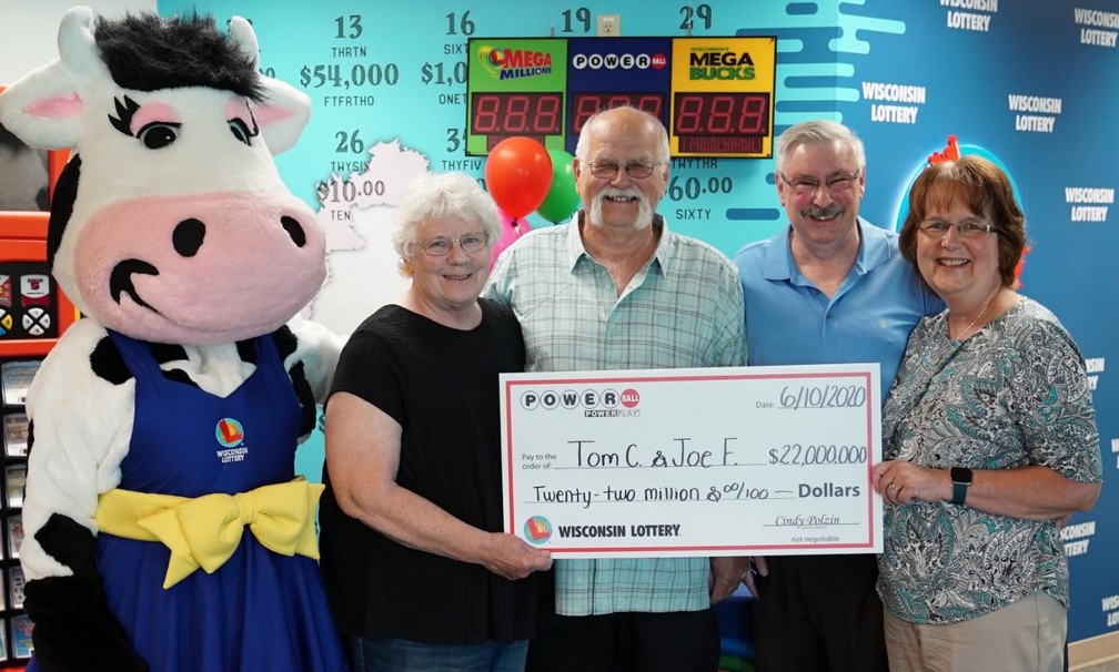 Tom Cook e Joseph Feeney posam com suas esposas segurando um cheque representando o prêmio no valor de 22 milhões de dólares — Foto: Wisconsin Lottery/Divulgação