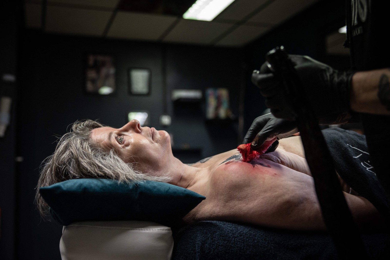 Paciente que passou por mastectomia realiza tatuagem no local em que ficava o seio — Foto: Simon Wohlfahrt/AFP