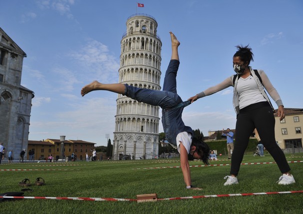 PISA, ITALY - MAY 30:  Tourists wearing face masks pose for a photograph near the tower of Pisa on May 30, 2020 in Pisa, Italy. The city of Pisa in Piazza dei Miracoli celebrated the reopening of the Tower of Pisa and of the city to the world with a Flash (Foto: Getty Images)